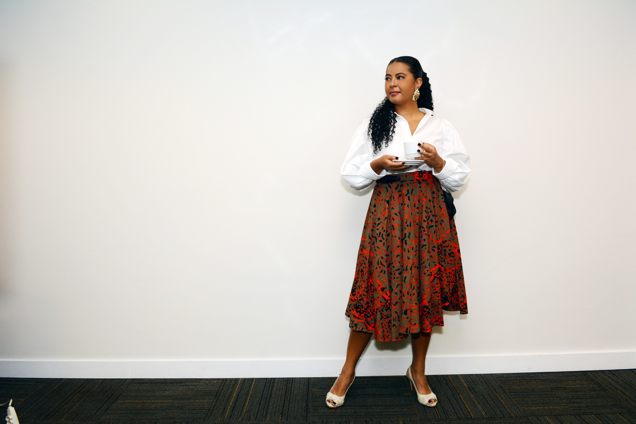 Heide Vieira em pé segurando uma xícara